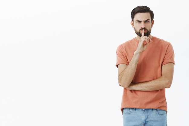 Hombre barbudo expresivo en camiseta naranja