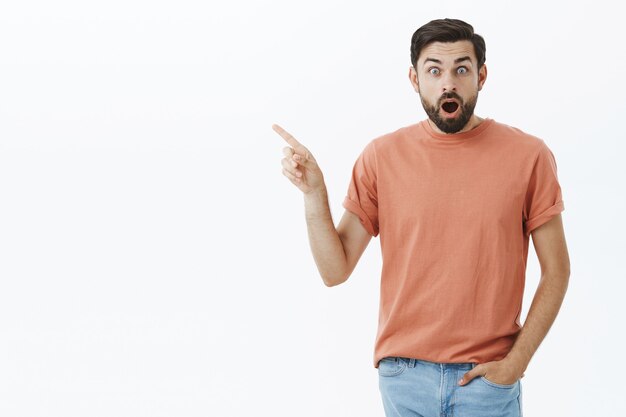 Hombre barbudo expresivo en camiseta naranja