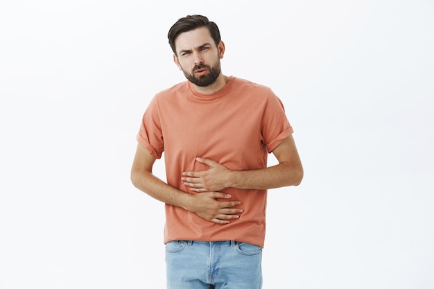 Hombre barbudo expresivo en camiseta naranja