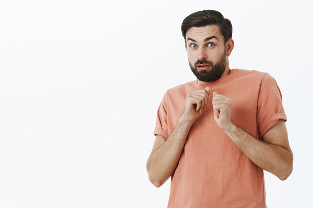 Hombre barbudo expresivo en camiseta naranja