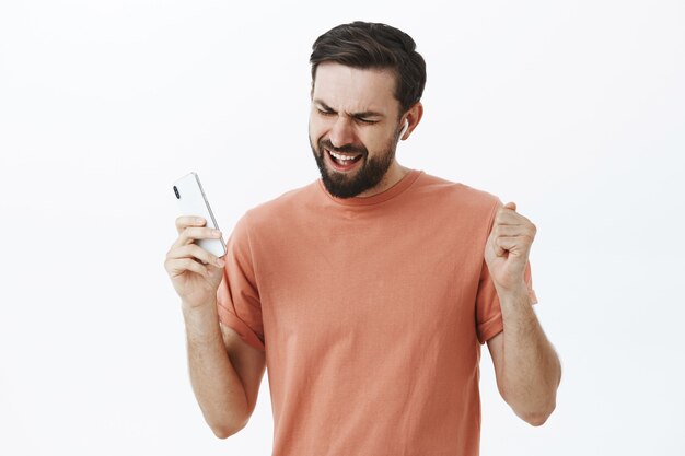 Hombre barbudo expresivo en camiseta naranja