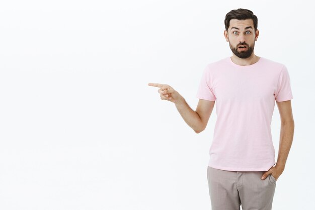 Hombre barbudo expresivo en camiseta rosa