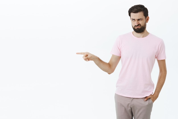 Hombre barbudo expresivo en camiseta rosa