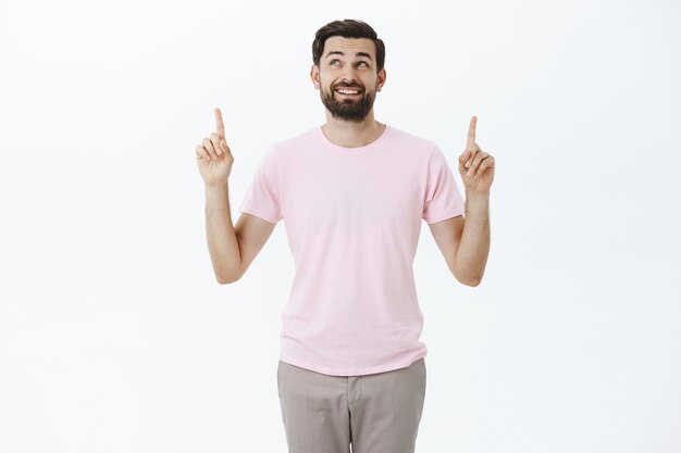 Hombre barbudo expresivo en camiseta rosa