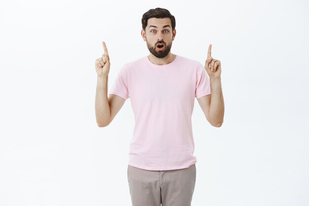 Hombre barbudo expresivo en camiseta rosa