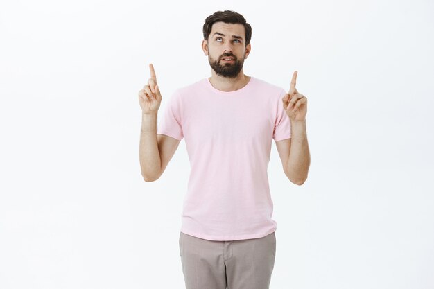 Hombre barbudo expresivo en camiseta rosa