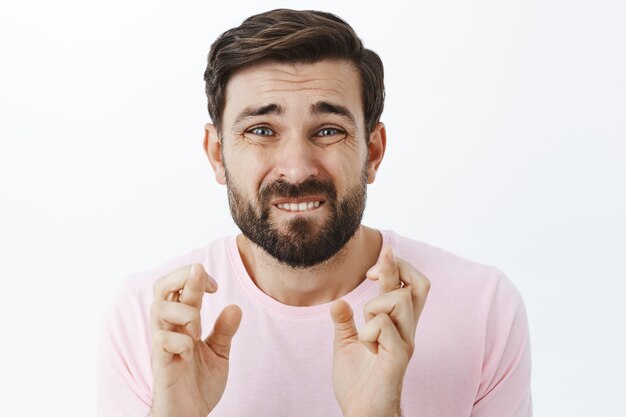 Hombre barbudo expresivo en camiseta rosa