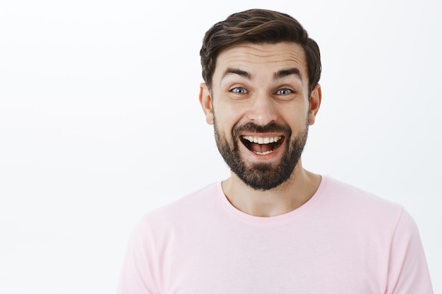 Hombre barbudo expresivo en camiseta rosa