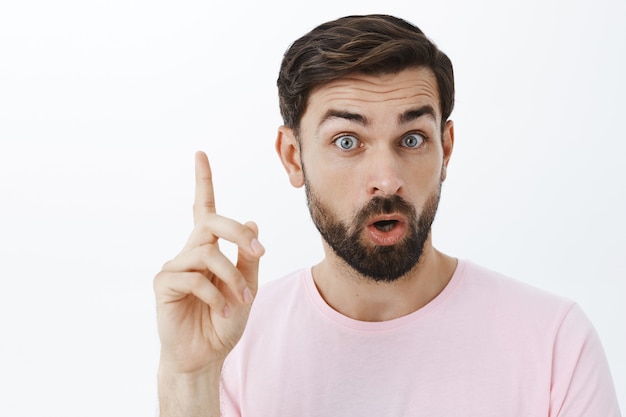 Hombre barbudo expresivo en camiseta rosa