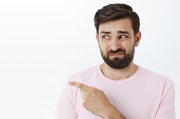 Hombre barbudo expresivo en camiseta rosa