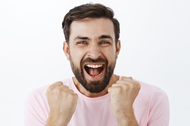 Hombre barbudo expresivo en camiseta rosa