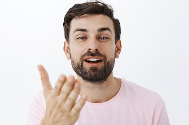 Hombre barbudo expresivo en camiseta rosa