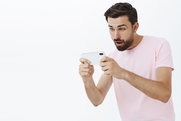 Hombre barbudo expresivo en camiseta rosa