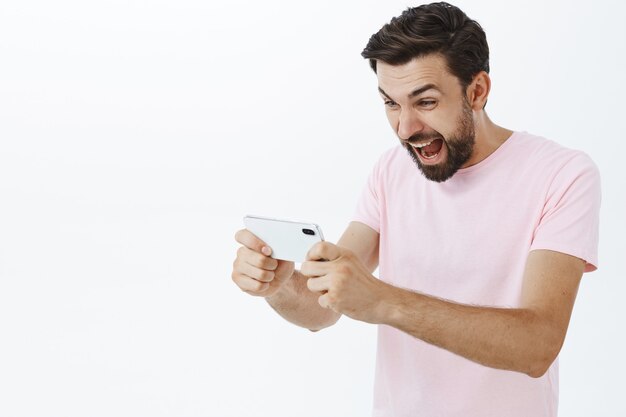 Hombre barbudo expresivo en camiseta rosa