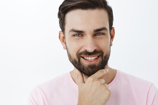 Hombre barbudo expresivo en camiseta rosa