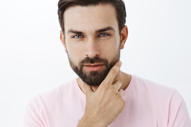 Hombre barbudo expresivo en camiseta rosa