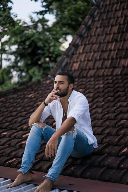 Hombre barbudo fumando en el techo