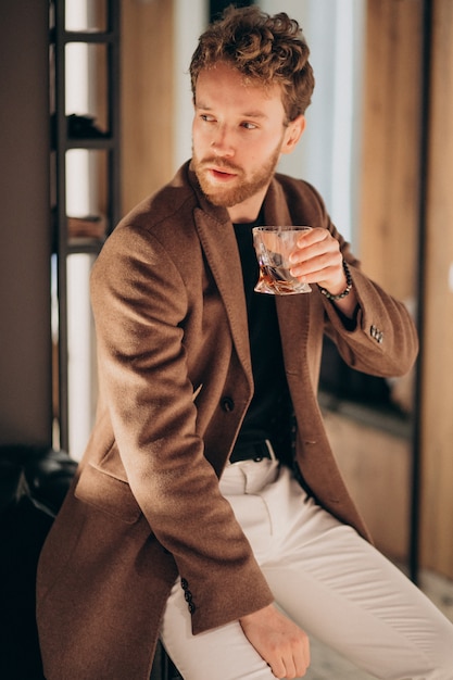 Hombre barbudo guapo bebiendo whisky