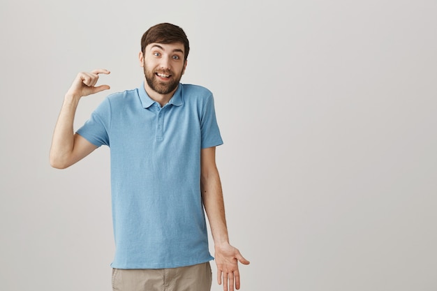 Hombre barbudo joven confundido posando