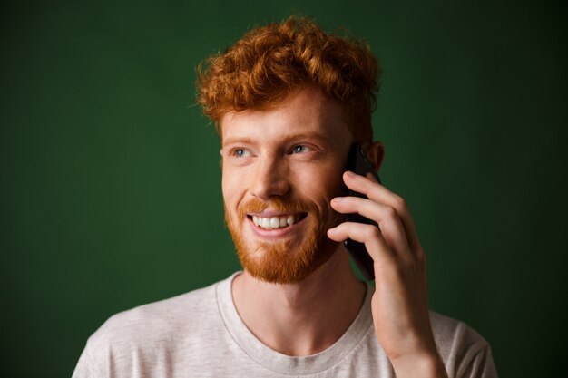 Hombre barbudo pelirrojo guapo hablando por teléfono