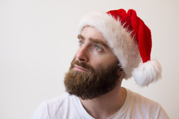 Foto gratuita hombre barbudo pensativo con sombrero de santa