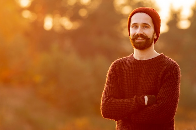 Foto gratuita hombre barbudo posando en la naturaleza con espacio de copia