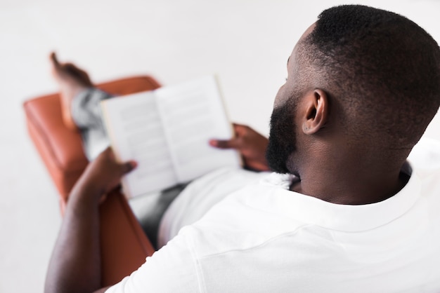 Hombre barbudo que disfruta leyendo en casa