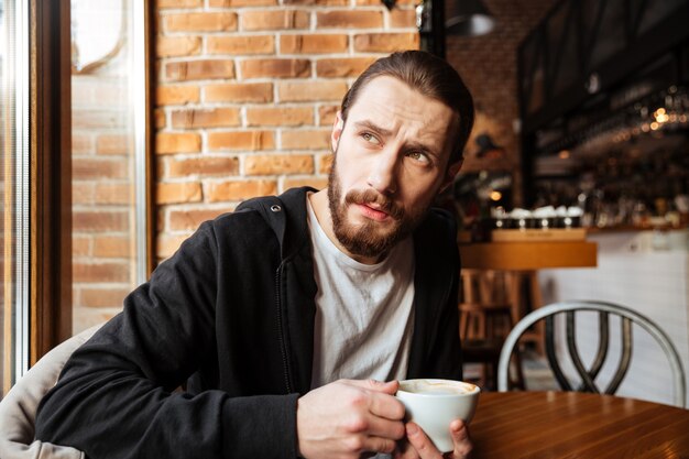 Hombre barbudo serio en cafe