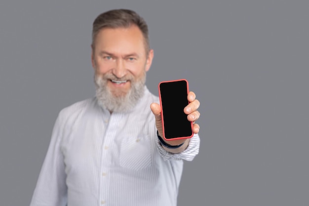 Hombre barbudo con un teléfono inteligente en las manos