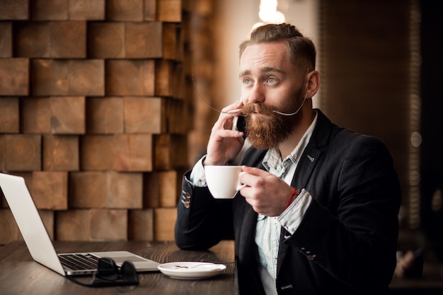 Foto gratuita hombre barbudo con teléfono