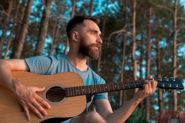 Hombre barbudo tocando la guitarra