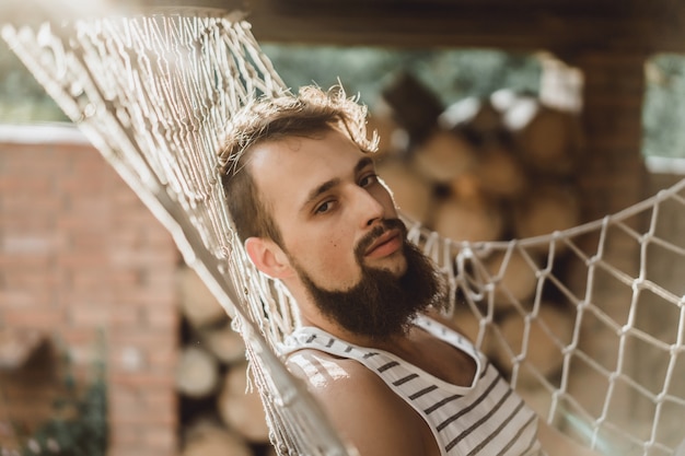 hombre barbudo tumbado tumbona en un cálido día de verano