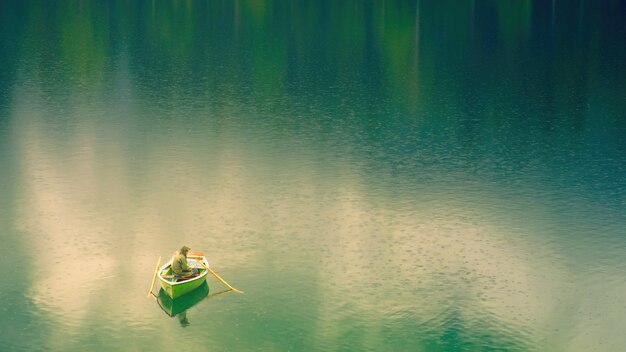 Hombre en un barco en un lago durante el día