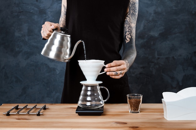 Hombre barista elaborando café. Método alternativo verter más.