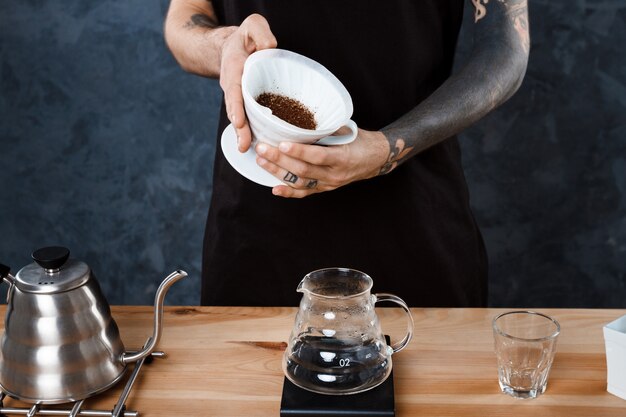 Hombre barista elaborando café. Método alternativo verter más.