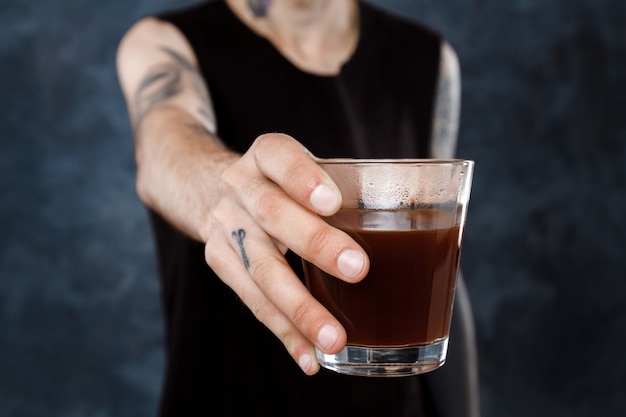 Hombre barista estirando el vaso con café