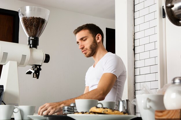 Hombre barista trabajando detrás del mostrador