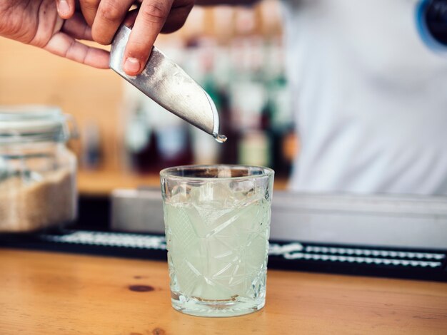 Hombre barman agregando hielo con pala.