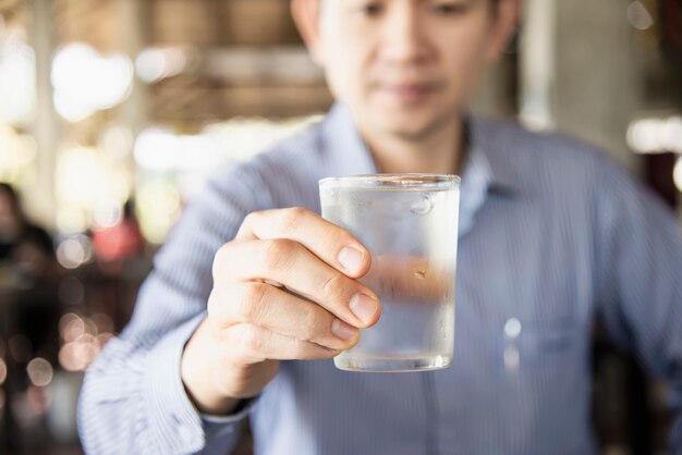 Hombre beber agua fresca fría pura en vaso