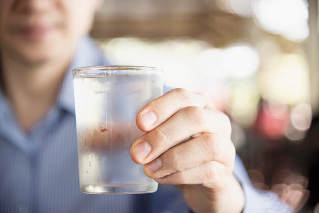 Hombre beber agua fresca fría pura en vaso