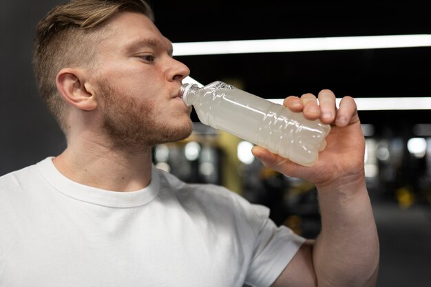 Hombre bebiendo bebidas en el gimnasio