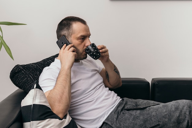 Hombre bebiendo y hablando por teléfono