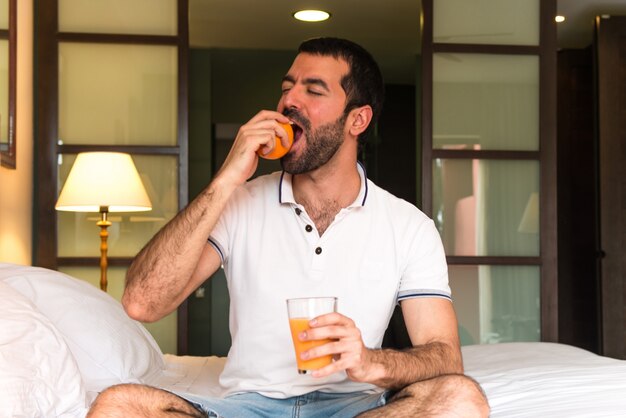 Hombre bebiendo jugo de naranja en un hotel