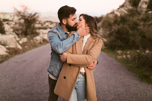 Foto gratuita hombre besando a hermosa mujer en carretera de montaña
