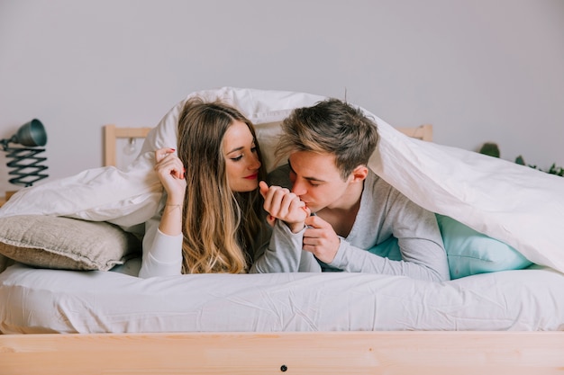 Foto gratuita hombre besando la mano de la mujer debajo de la manta