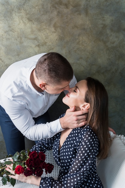 Foto gratuita hombre besando a mujer con flores