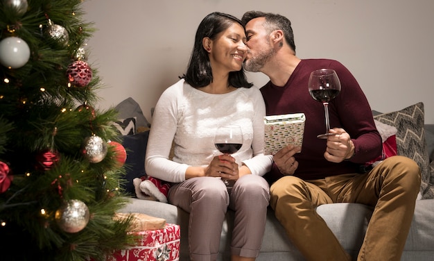 Foto gratuita hombre besando a mujer para navidad