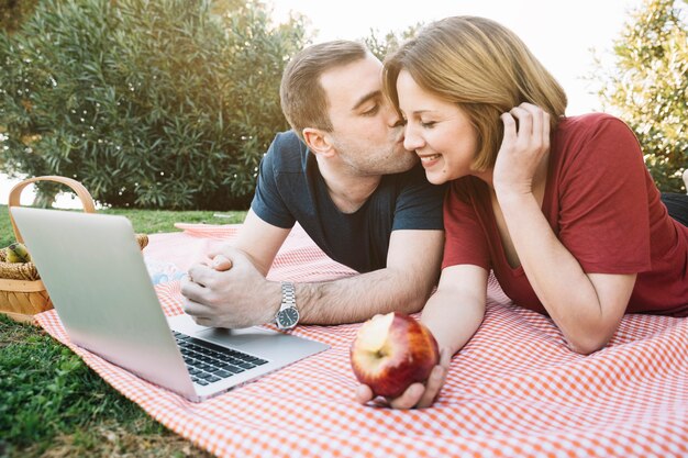 Hombre besando a mujer en picnic