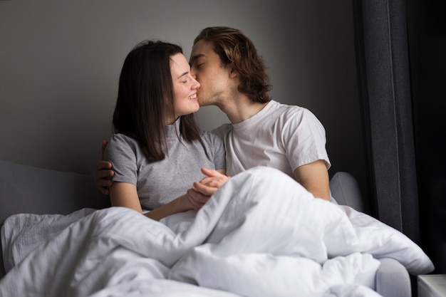 Hombre besando a la novia mientras cogidos de la mano