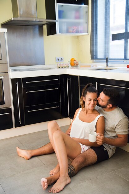 Hombre besando a su esposa en la cocina